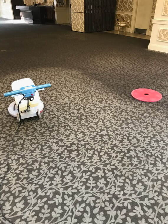 A PJS technician running a commercial carpet extractor in an office corridor